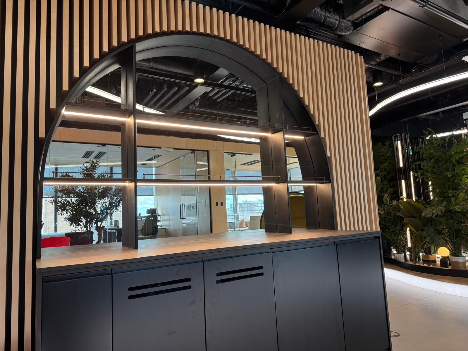Integrated LED lighting within a curved refreshment area and arched joinery for a Birmingham video game company office